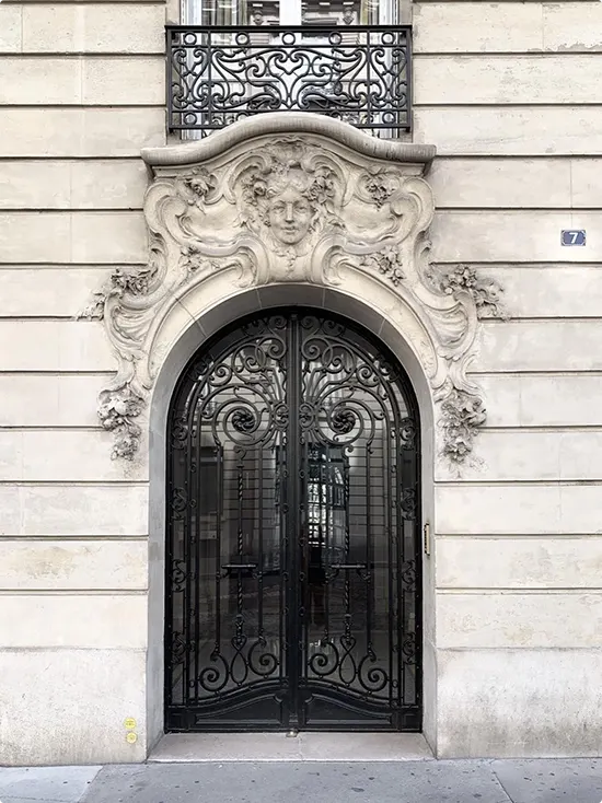 Black Gate Doors in Wrought Iron Scrollwork with a Carved Face Above