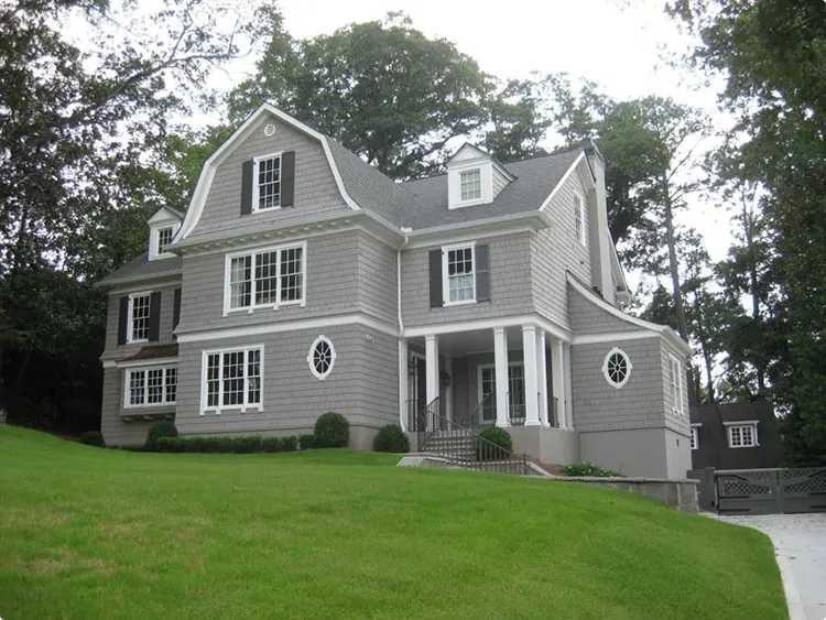 Gray Gambrel House with Round Windows and Black Shutters