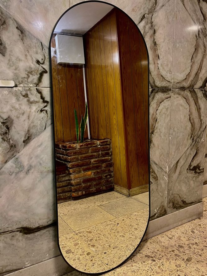Pill Mirror Leaning Against Dramatic Marble Wall