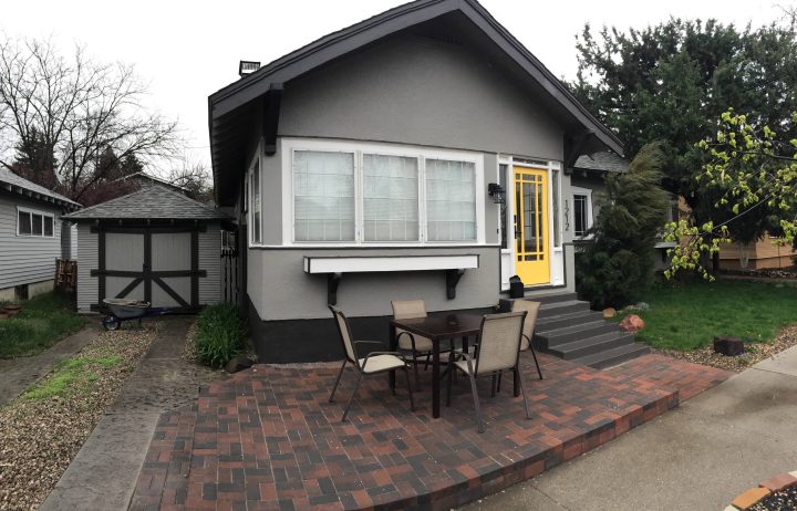 Gray Bungalow with Yellow Entry Herringbone Brick Patio