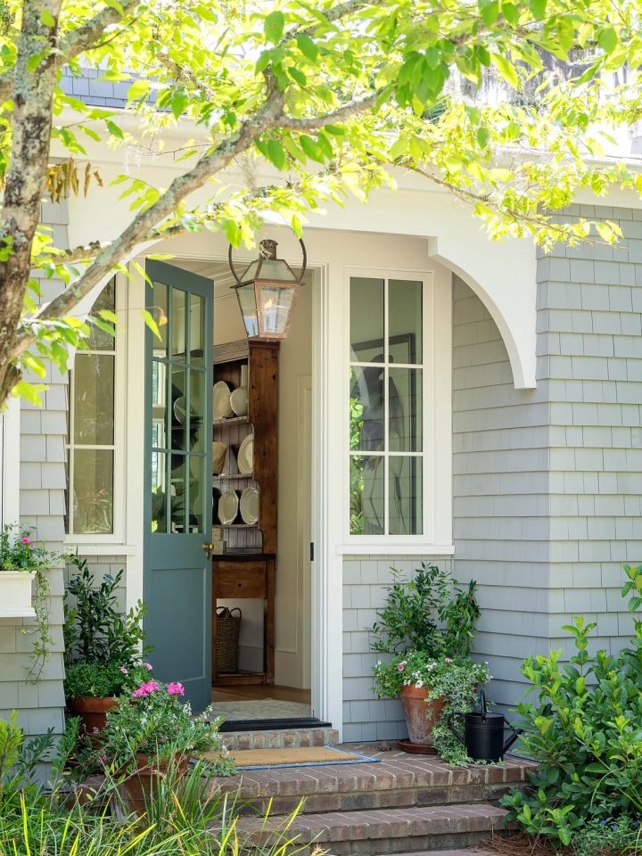 Open Dutch door in slate blue below a white curved overhang