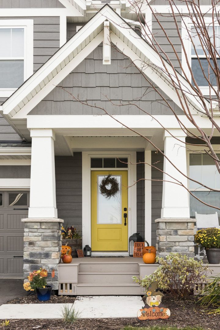 Yellow Door with Stone Columns and Fall Decor