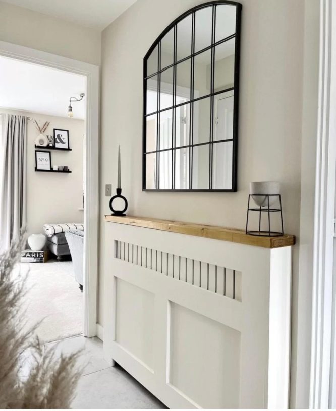 A window-pane style mirror sits above the radiator cover