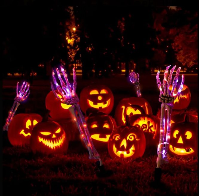Glowing Skeleton Hand Lights in a Carved Pumpkin Patch