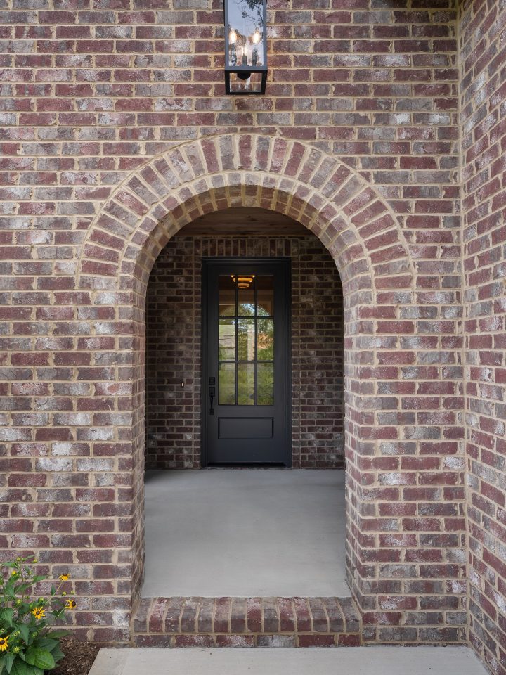 Brick archway with a black door